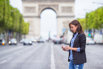 Beautiful woman holding a phone on the Champs Elysees in Paris