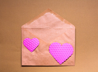 Envelope with two valentine hearts on orange background