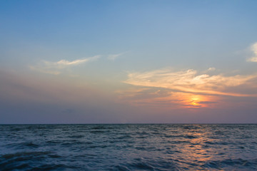 Obraz premium Sunset over the sea with clouds over the water surface