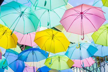 Fototapeta na wymiar Hanging colorful umbrellas, on the street and blue sky.