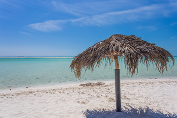 Beach Umbrella made of palm leafs on exotic beach