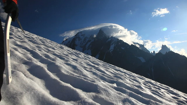 Lone mountaineer climbing a snowy ridge in winter season - low angle view -