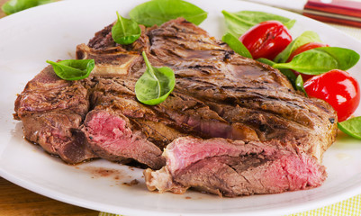 Beef steak served with green salad.