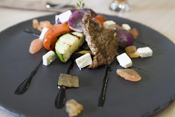 Meat with vegetables and cheese in restaurant