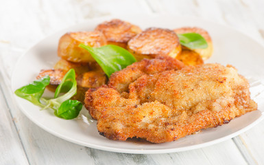 Homemade Breaded Schnitzel with Potatoes and Salad.