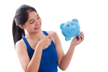 Happy woman pointing at piggy bank isolated on white background