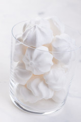 Closeup of meringue cookies in a glass on a white background. selective focus