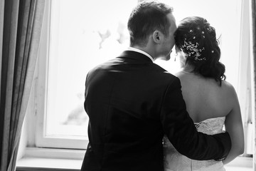 Happy beautiful bride and handsome romantic groom in suit huggin