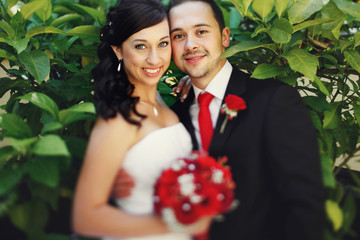 Handsome romantic groom in suit and beautiful brunette bride pos