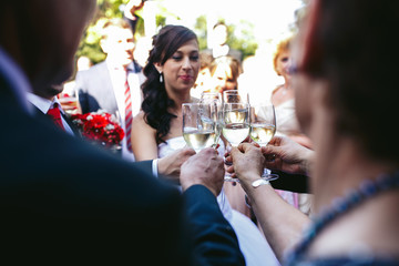 Happy beautiful bride drinking champagne at wedding reception wi