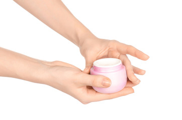 Body care and health topic: a woman's hand holding a pink jar of cream isolated on white background in studio