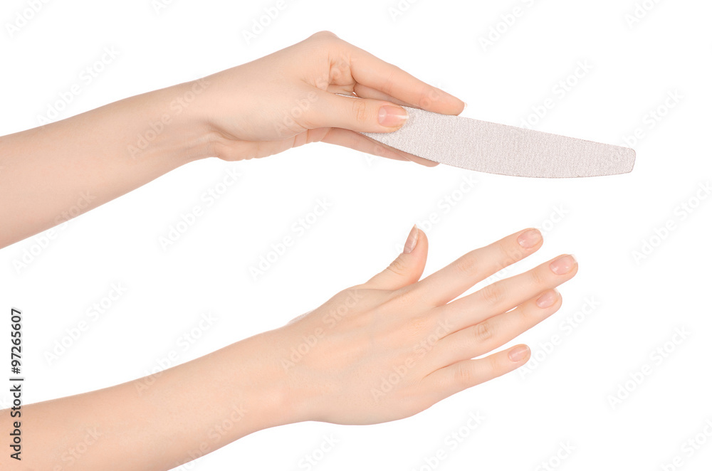 Wall mural health and hand care topic: a woman's hand holding a nail file for manicure isolated on white backgr