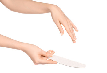 Health and hand care topic: a woman's hand holding a nail file for manicure isolated on white...