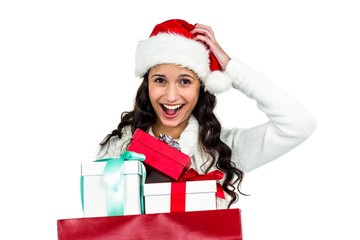Smiling woman with christmas hat holding gifts