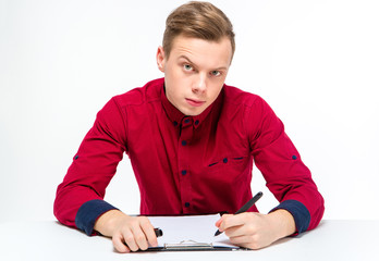 Suspicious curious male with raised eyebrow writing on clipboard