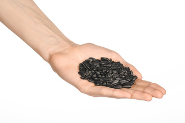 Nuts and meal preparation topic: human hand holding roasted sunflower seeds on a white isolated background in studio
