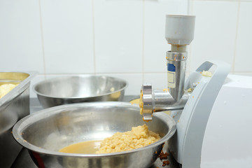 Professional  mincer processes fruit in a small culinary shop