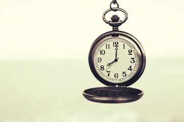 vintage pocket watch on blurred background
