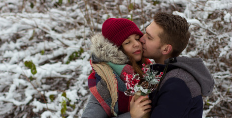 Obraz premium Cute guy and beautiful girl hugging in winter park