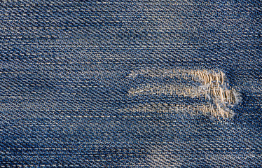 Jeans texture or background denim blue with tear.