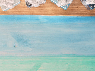 Wooden brown, green and blue pastel background with christmas tree decorations on the top, top view, copy space, retro toned effect