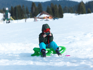 Fototapeta na wymiar young boy have fun on winter vacatioin and play games on phone