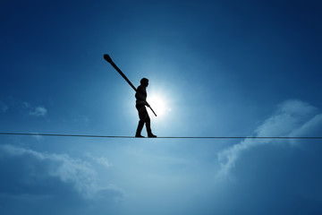 Concept of risk taking and challenge highline walker in blue sky