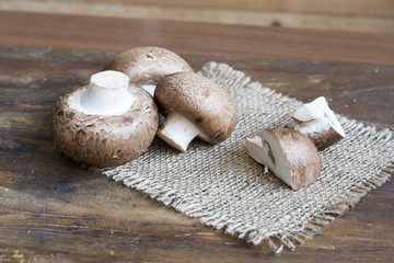 Champignon mushrooms on bagging on wooden a wooden background