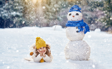 girl playing with a snowman