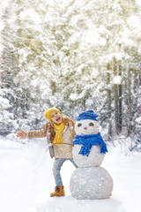 girl playing with a snowman