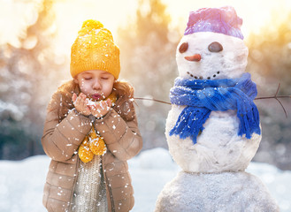 girl playing with a snowman
