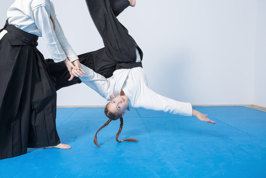 Two girls in black hakama practice Aikido - Powered by Adobe