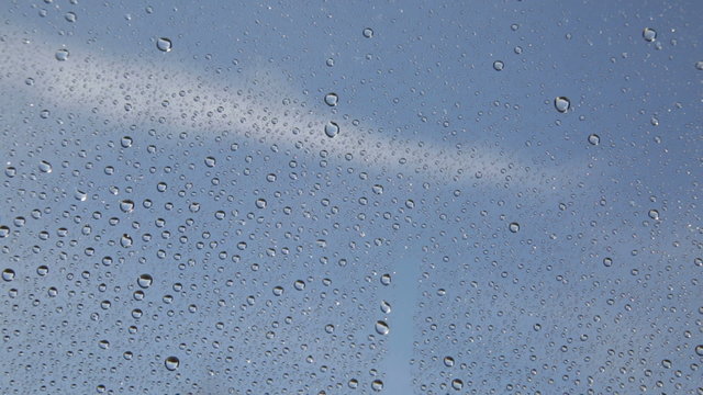 Vetro bagnato davanti allo sfondo del Cielo Blu