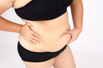 Woman's fingers measuring her belly fat