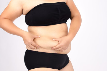 Woman's fingers measuring her belly fat