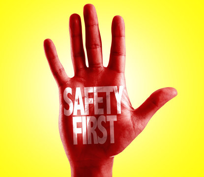 Safety First written on hand with yellow background