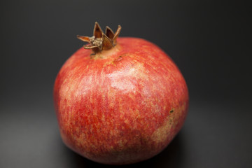 Spanish juicy ripe pomegranate closeup on a dark background