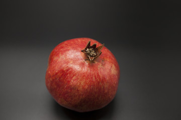 Fototapeta na wymiar Spanish juicy ripe pomegranate closeup on a dark background