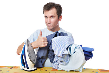 Happy man with iron and heap of shirts showing gesture thumbs up