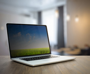 computer on wooden table in room