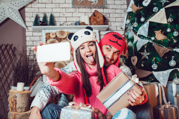 Couple in love in Christmas decorations make the selfie
