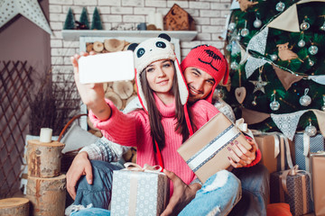 Couple in love in Christmas decorations make the selfie