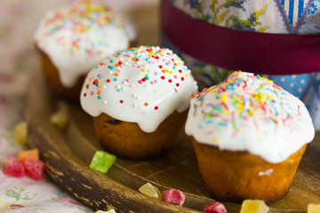 Куличи пасхальные с глазурью и цукатами на деревянном подносе