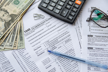 Obraz premium tax forms 1040 with the glasses, money and the pen