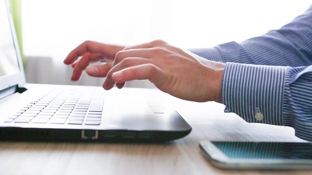 mani di uomo di affari scrivono con tastiera di notebook nell'ufficio di lavoro