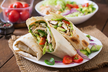 Fototapeta Fresh tortilla wraps with chicken and fresh vegetables on plate obraz