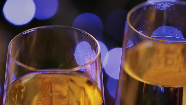 champagne glasses against christmas tree bokeh lights