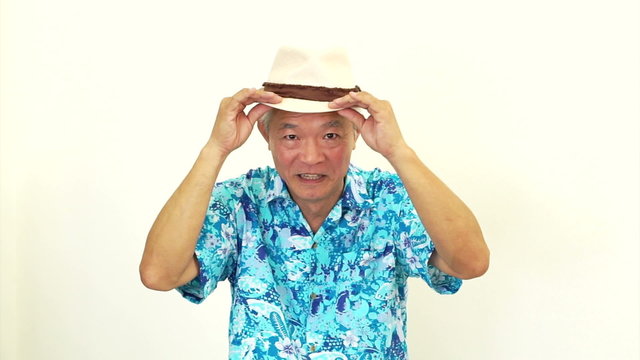 Asian senior man wearing blue hawaii shirt and hat. Ready to go vacation