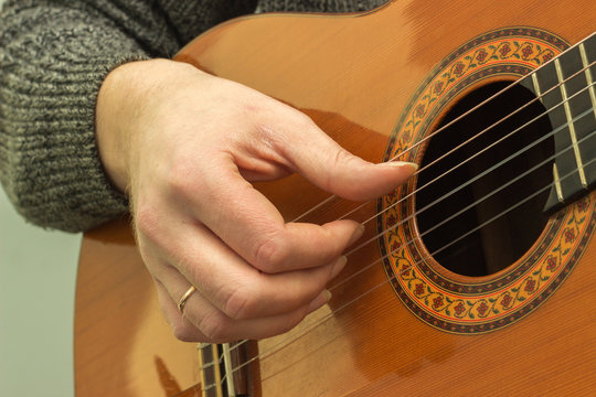 The fingers on the strings of a guitar playing