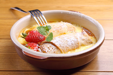 rolled pancakes on a plate with honey and powdered sugar